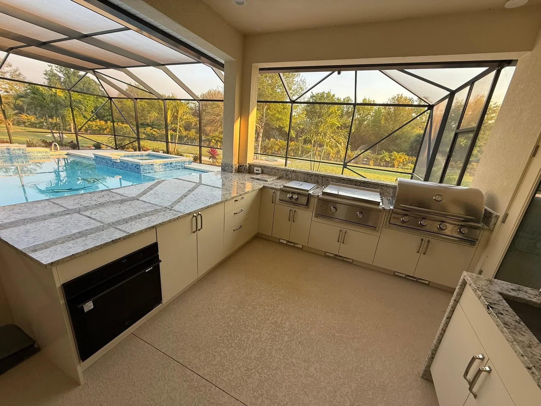 Completed Apex outdoor kitchen beside a Florida pool, with light cabinetry and integrated appliances